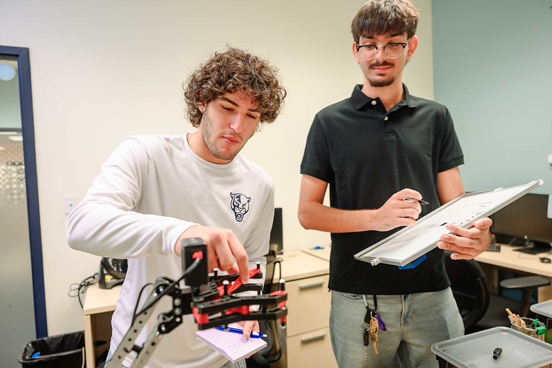 Students working together to alter robot