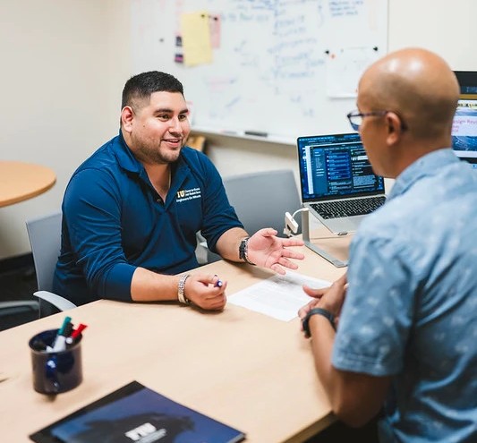 Faculty meeting with student to mentor over research 