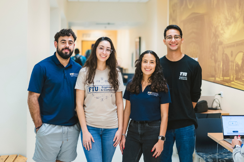 Four FIU students smiling towards camera